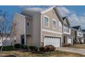 Attractive beige two-story home with a two-car garage and manicured landscaping at 1952 Grassy Banks Dr, Raleigh, NC 27610