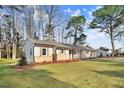 A cozy single-story home with stone accents, shutters, and a well-maintained lawn exudes warmth at 210 S General Lee Ave, Dunn, NC 28334