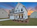 Beautiful home exterior with brick and white siding, accented by blue shutters and a well-maintained green lawn at 2156 Pink Peony Cir # 157, Durham, NC 27703