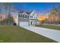 Attractive two-story home with a brick and white exterior, showcasing blue shutters and a spacious front yard at 2156 Pink Peony Cir # 157, Durham, NC 27703
