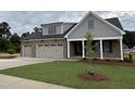 Charming home with a three car garage, gray and brick exterior, and a manicured front lawn at 2328 Eagle Shot Ct # 18, Fuquay Varina, NC 27526