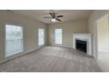 Bright living room featuring a cozy fireplace, neutral carpet, and abundant natural light at 271 Mayors Lane Ln, Wendell, NC 27591
