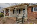 Inviting front porch with brick supports, black railings, and neutral siding at 2720 Amherst Ave, Burlington, NC 27215