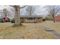 Traditional brick house with mature trees and a concrete walkway at 2720 Amherst Ave, Burlington, NC 27215