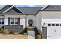 Inviting front entrance with a black door, complemented by manicured landscaping at 405 Joseph Alexander Dr, Fuquay Varina, NC 27526