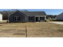 Charming one-story home featuring gray siding, black shutters, covered entry, and a well-manicured lawn at 44 Harvest Hills Ln, Dunn, NC 28334