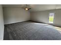 Bright living room featuring neutral walls, plush carpeting, and a ceiling fan at 44 Harvest Hills Ln, Dunn, NC 28334