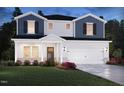 Charming two-story home with blue and white siding, a covered porch, and a two-car garage at 547 White Birch Ln, Angier, NC 27501