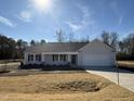 Charming one-story home features a manicured lawn and inviting front porch, with an attached two-car garage at 73 Phil Jack Rd, Dunn, NC 28334
