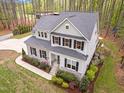 Aerial view of a gracious two-story home with dark shutters and professional landscaping on a large lot at 749 Bowden Rd, Chapel Hill, NC 27516