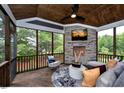 Cozy screened porch with wood ceiling and floors, stone fireplace, and comfortable seating at 0 Lyla'S Ln, Efland, NC 27243