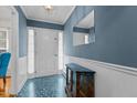 Inviting foyer with blue walls, patterned flooring, and elegant wainscoting at 102 Trinity Dr, Elon, NC 27244