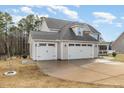 Side view of the large three-car garage featuring an extensive driveway at 104 Coats Ridge Dr, Benson, NC 27504