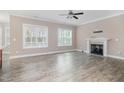 Open living room with wood-look flooring, fireplace, and bright windows at 104 Coats Ridge Dr, Benson, NC 27504
