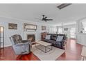 Comfortable living room showcasing a fireplace, ceiling fan, hardwood floors, and a view of the dining area at 11 D'Ango Cir, Angier, NC 27501