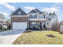 Lovely two-story home showcasing a covered porch, two-car garage, and well-maintained landscaping at 113 Palladium Ct, Elon, NC 27244