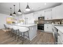 Modern kitchen with stainless steel appliances, white cabinetry, a large island, and pendant lighting at 113 Seneca Dr # 759, Louisburg, NC 27549