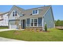 Beautiful two-story home with stone veneer, a 2-car garage, and lush green lawn and landscape at 121 Willow Cameron Way, Angier, NC 27501