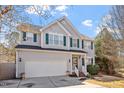 Two-story home with gray siding, green shutters, and attached two-car garage showcasing a well-maintained lawn at 1218 Twelve Oaks Ln, Apex, NC 27502