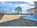 Expansive backyard with a well-maintained lawn, mature trees, and a covered patio area at 197 Royal Oak Ln, Garner, NC 27529