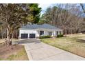 Beautiful home with a long driveway leading to a two-car garage and a covered front porch at 208 Hunting Lodge Rd, Clayton, NC 27520