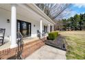 Welcoming front porch with rocking chairs, brick steps, and a stylish front door at 208 Hunting Lodge Rd, Clayton, NC 27520