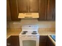 Kitchen featuring wooden cabinets, a white oven, and light colored countertops at 228 Adams St, Cary, NC 27513