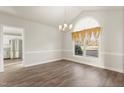 Formal dining room with hardwood floors, a chandelier and arched window with ornate curtains at 2318 Rogers Rd, Graham, NC 27253