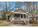 Charming home with a covered porch, brick foundation, and mature landscaping at 2513 Drexall Ave, Durham, NC 27704