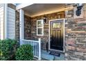Inviting front porch featuring stone accents, a cozy seating area, and manicured greenery at 304 Presenteer Trl, Apex, NC 27539