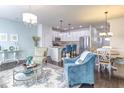 This is an open-concept living room and kitchen with hardwood floors and elegant decor at 304 Presenteer Trl, Apex, NC 27539