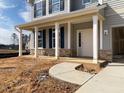 Inviting front porch with white columns and stone accents, leading to the main entrance at 322 N Maple Walk Walk # 237, Garner, NC 27529