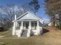 Craftsman home with a light blue exterior and covered front porch, showing steps to the entry at 523 E Nelson Ave, Wake Forest, NC 27587