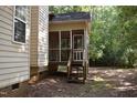 View of the screened in back porch, complete with stairs leading to the yard at 5402 Whisperwood Dr, Durham, NC 27713