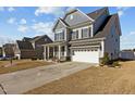 Beautiful gray home with a spacious driveway, attached garage, and landscaped front yard, perfect for curb appeal at 5601 Garnet Meadow Rd, Knightdale, NC 27545