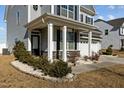 Inviting front porch with white columns and decorative stone accents, creating a welcoming entrance to the home at 5601 Garnet Meadow Rd, Knightdale, NC 27545