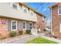 A well-maintained brick townhome featuring blue shutters, tidy landscaping, and a welcoming entrance at 627 W Front St # C, Burlington, NC 27215