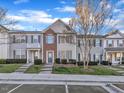 Inviting townhouse exteriors with landscaped lawns and concrete sidewalks in residential area at 706 Canyon Lake Cir, Morrisville, NC 27560