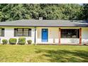 Close-up of a home's blue front door with black shutters and a well-manicured lawn at 7414 Virgilina Rd, Roxboro, NC 27574