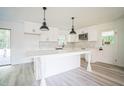 Bright, all-white kitchen with a large island, modern appliances, and stylish backsplash at 7414 Virgilina Rd, Roxboro, NC 27574