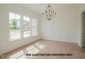 Bright dining room featuring three windows, decorative chandelier and hardwood floors at 825 Willow Tower Ct, Rolesville, NC 27571