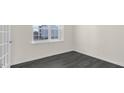 Well-lit room with dark wood-look flooring and bright white trim at 94 Paper Birch Way, Fuquay Varina, NC 27526