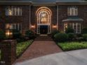 Home exterior at dusk, highlighting the walkway and illuminated arched entry way at 107 Marseille Pl, Cary, NC 27511