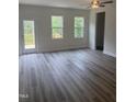 Open-concept living room featuring luxury vinyl plank flooring, a ceiling fan and a glass door leading to the deck at 122 Reece Dr, Sanford, NC 27332