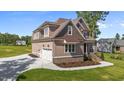Beautiful home featuring an attached two-car garage and manicured lawn with detailed trim and updated landscaping at 165 Cotton Fields Ln # 25, Fuquay Varina, NC 27526
