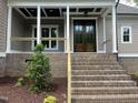 Inviting front porch with double doors, brick steps, and white columns showcasing architectural details at 165 Cotton Fields Ln # 25, Fuquay Varina, NC 27526