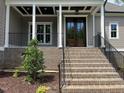 Inviting front porch featuring brick stairs, black railing, and a stylish entryway with a double door at 165 Cotton Fields Ln # 25, Fuquay Varina, NC 27526