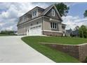 Side view of a gray home with a two-car garage and a concrete driveway on a manicured lawn at 165 Cotton Fields Ln # 25, Fuquay Varina, NC 27526