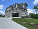 Side-entry garage with an open door and paved driveway leading to the structure at 165 Cotton Fields Ln # 25, Fuquay Varina, NC 27526
