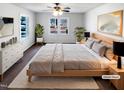 Cozy staged bedroom with neutral decor, bright windows, ceiling fan and modern furnishings at 204 Colonial Dr, Clayton, NC 27527